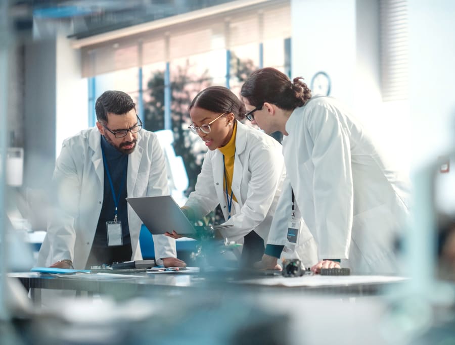 A research team gathered around a laptop