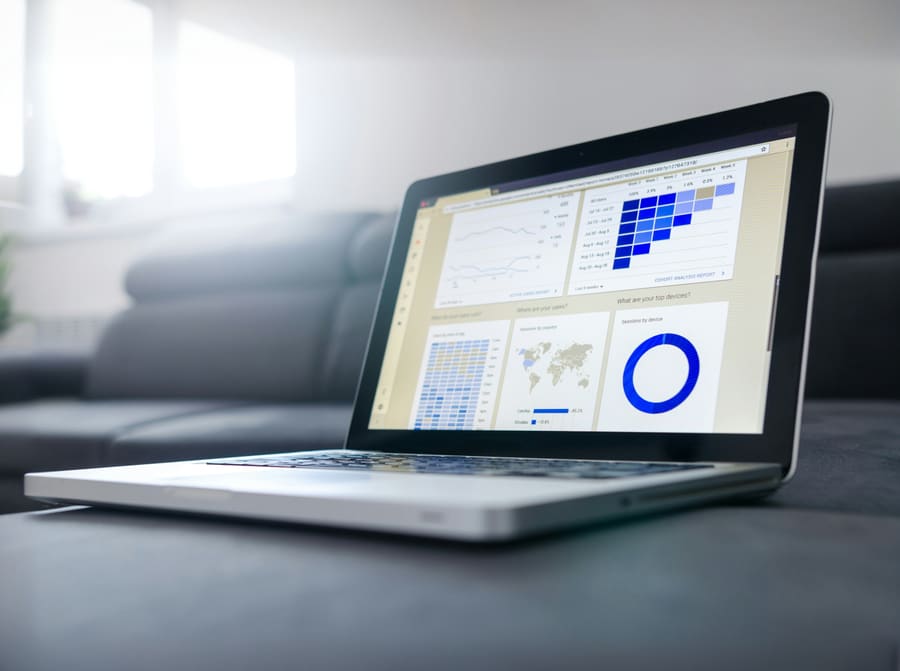 A laptop showing an analytics dashboard of charts and a world map