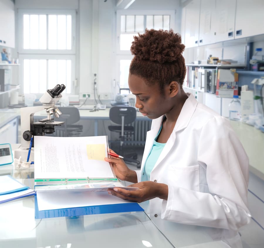 A pharmacist working through a binder of policies