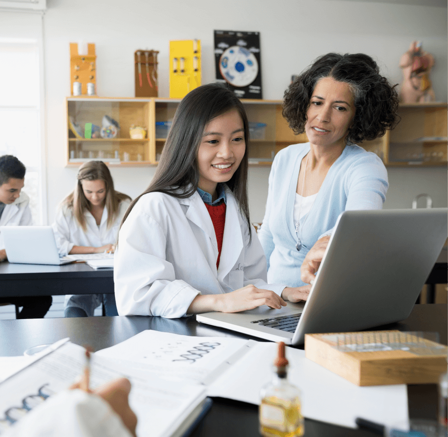 Pharmacists working through a case around a laptop