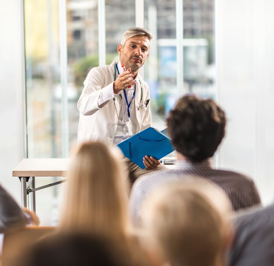 A pharmacist presenting to a seated audience