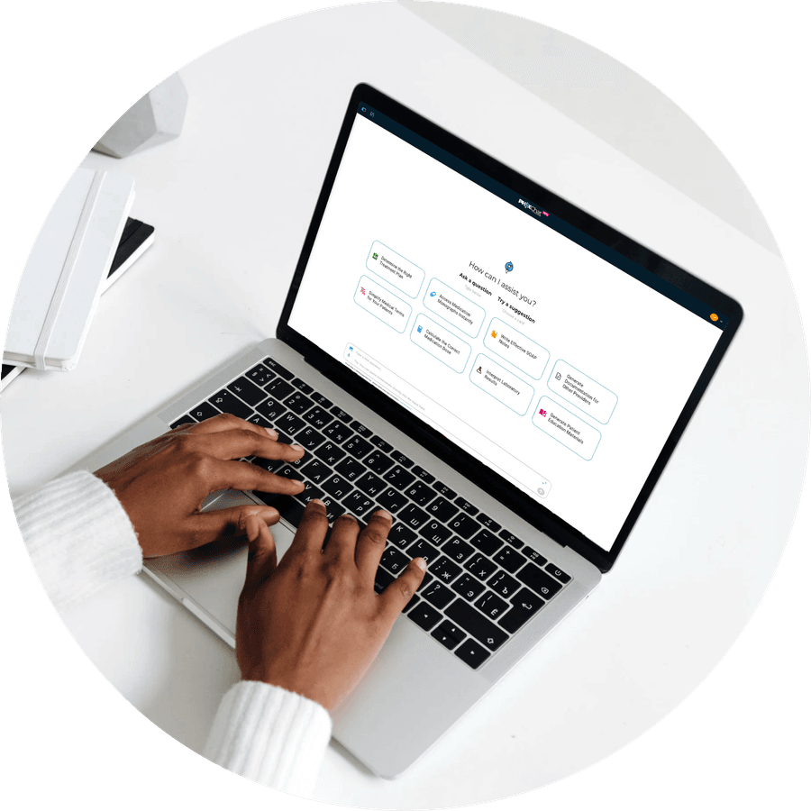 A pharmacist typing a question into PhoxChat on a laptop