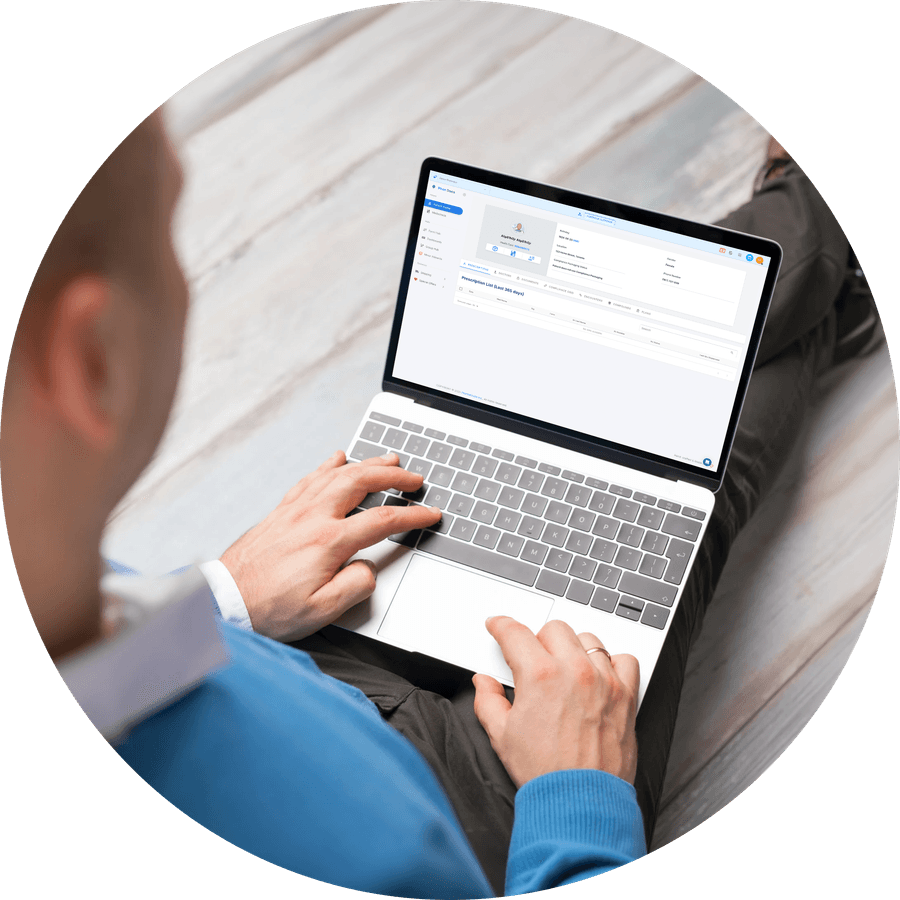 A pharmacist completing a PhoxDocs form on a laptop