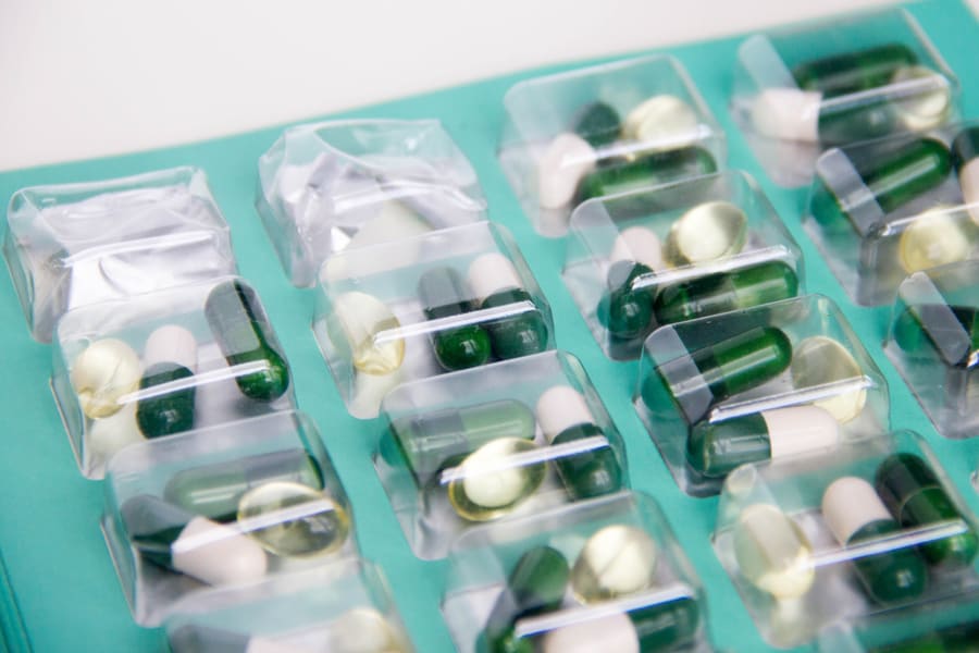 Green and white capsules in blister packs