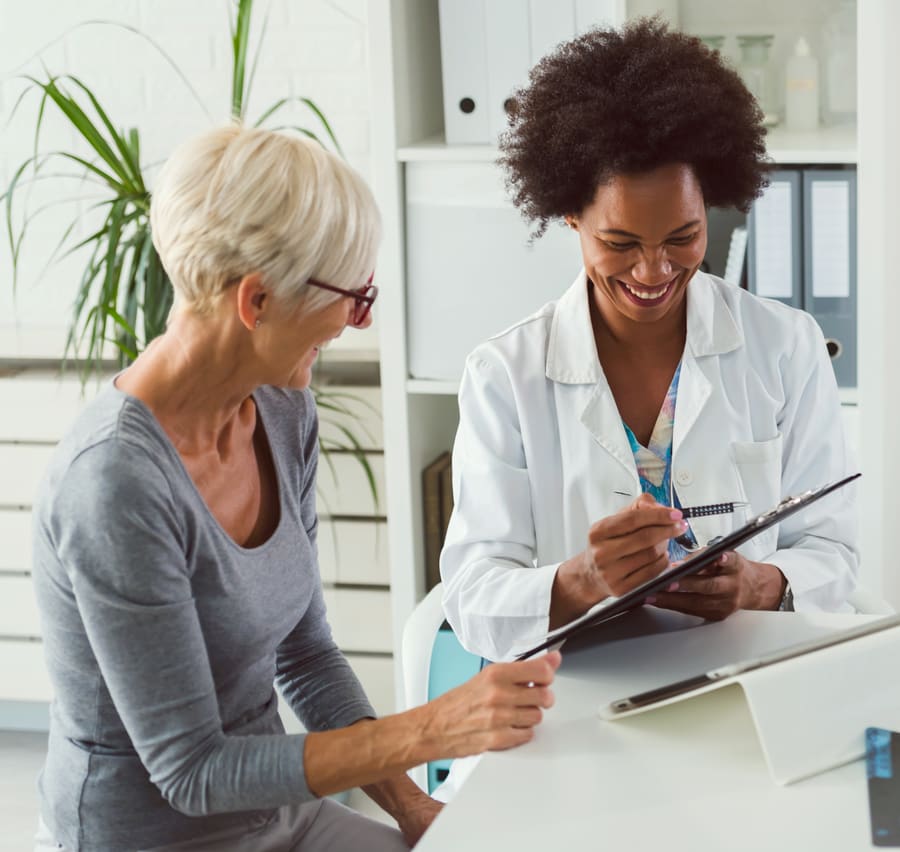 A pharmacist going through an invoice with a patient