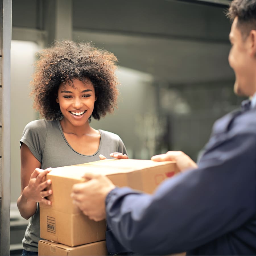 A patient taking a parcel from a courier at the door