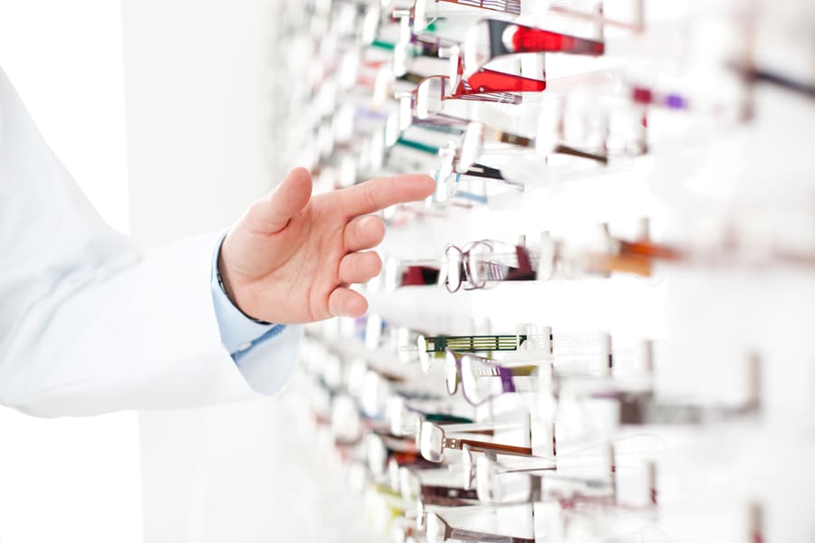A hand reaching for stock on a dispensary shelf