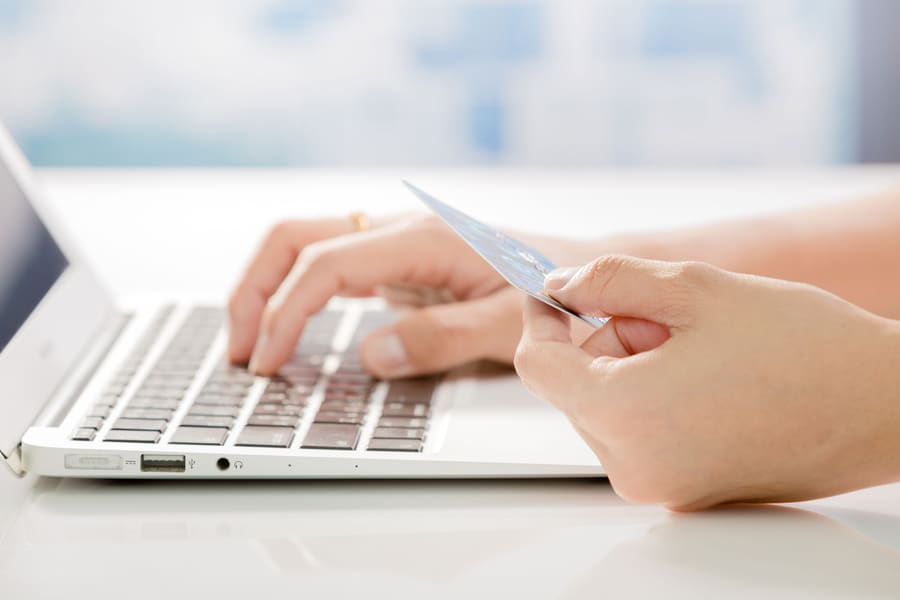 A customer paying by card at a laptop