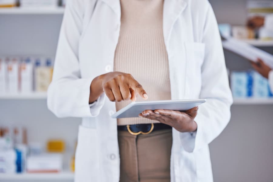 A pharmacist looking something up on a tablet
