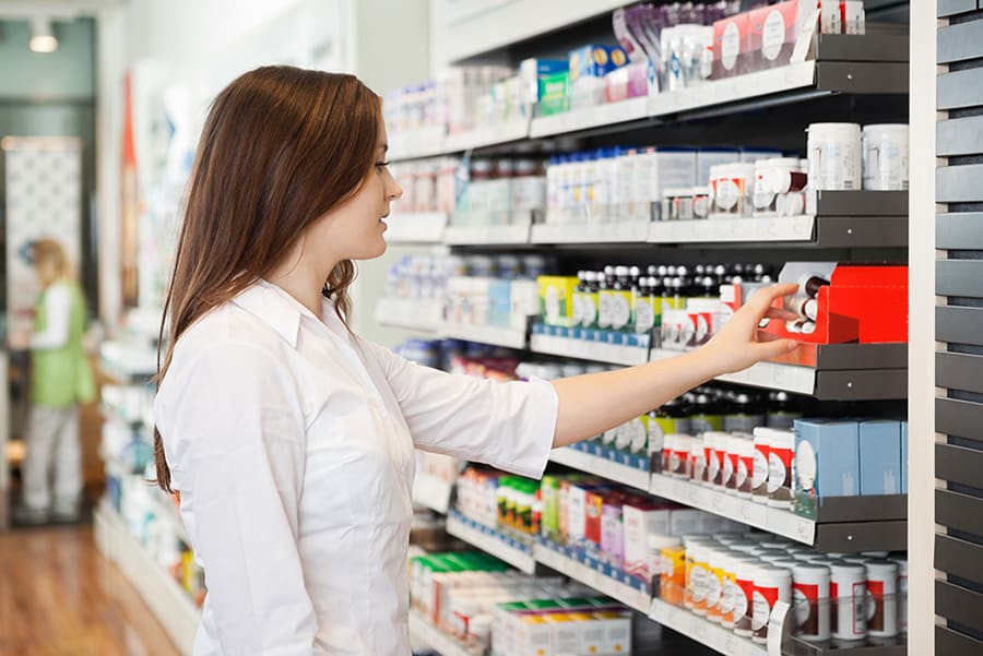 A pharmacist taking a specialty medication from the shelf